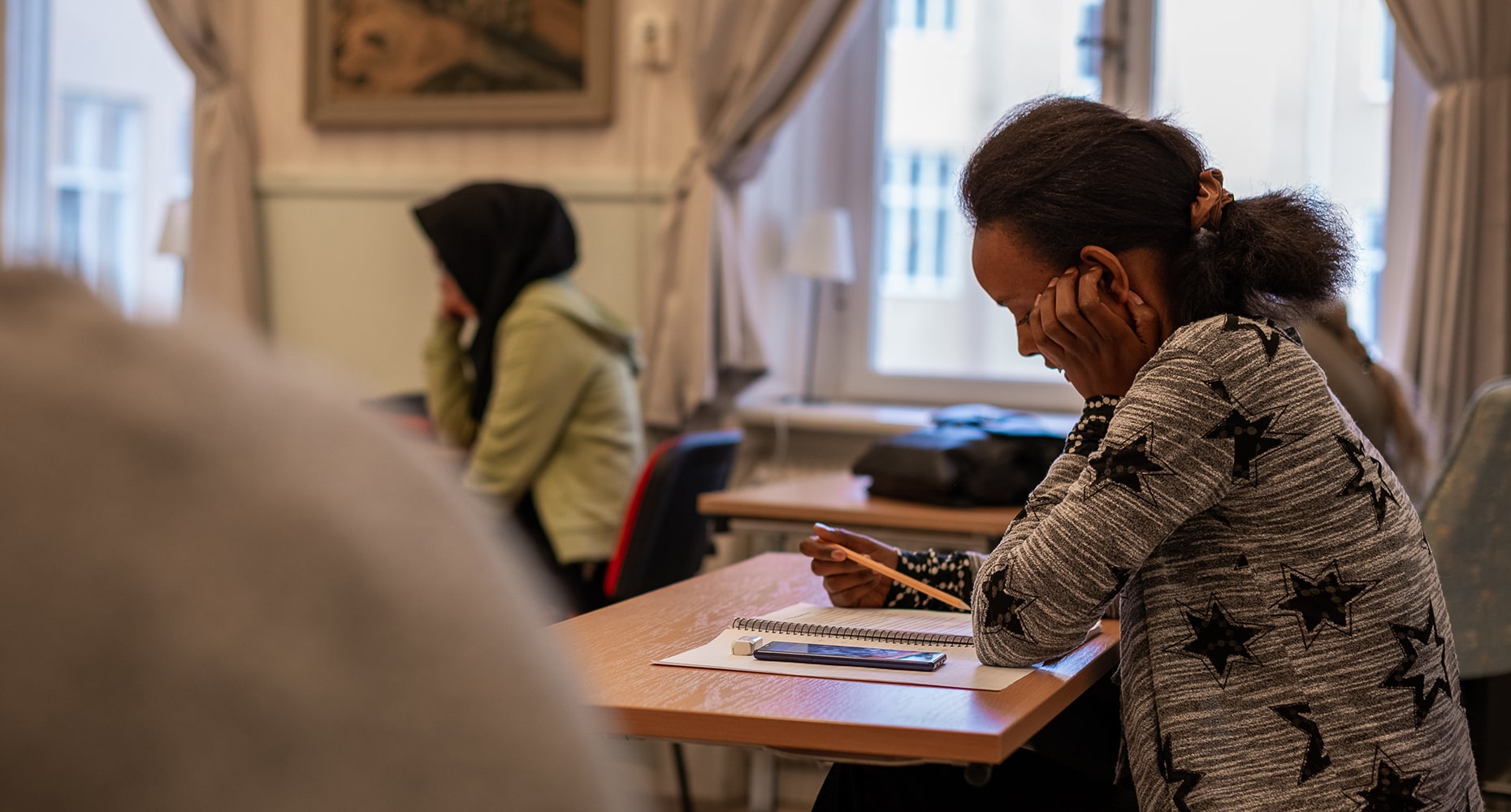 studerande vid baskurs sitter vid bord